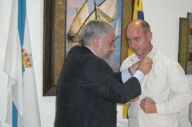 O presidente do Centro Gallego de Puerto La Cruz, Manuel Sinde, impón a Santiago Camba o Botón de Ouro.