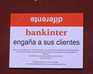 Os manifestantes pegaron cartaces na fachada da sede de Bankinter en Compostela