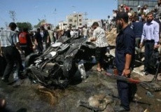 Palestinos observan un coche bombardeado nun ataque israelí