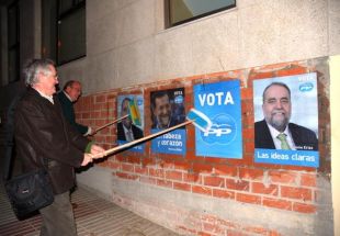 Hernández Cochón pegando carteis do PP polas rúas de Sada