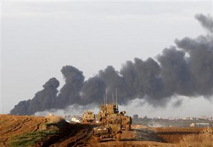 Tanques israelís avanzan cara a Gaza. Ao fondo, fume de explosións