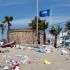 Imaxe dunha praia con bandeira azul, mais invadida polo lixo (Foto: Adega)
