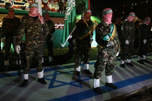 Membros de Hamás, esta cuarta feira, sobre a bandeira de Israel