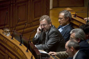Fazenda, co teléfono, nunha sesión da Assembleia da República. Á súa dereita, Francisco Louçã, candidato do BE nas eleccións do domingo
