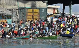 Habitantes da capital saen en chalanas para abordar un barco que os leve a Jeremie, localidade do norte de Haití (clique para ampliar)