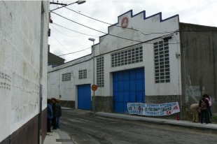 Unha faixa pendurada na fábrica na que se pode ler "Conservas Pérez Lafuente, as fixas descontinuas queremos traballar xa! CIG"