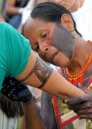 Indíxena da etnia Caiapó axúdalle a pintarse a un participante na marcha inaugural do FSM