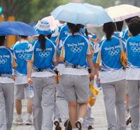 Mozas da organización das Olimpíadas baixo a choiva